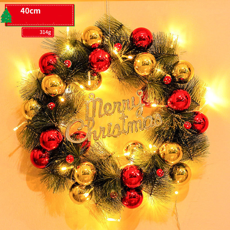 Decorative Christmas wreath with red and gold ornaments and 'Merry Christmas' text, glowing warmly.