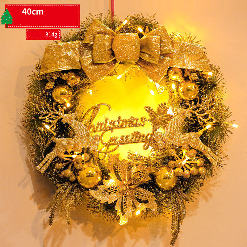 Decorative Christmas wreath with gold lights and ornaments on a plain background