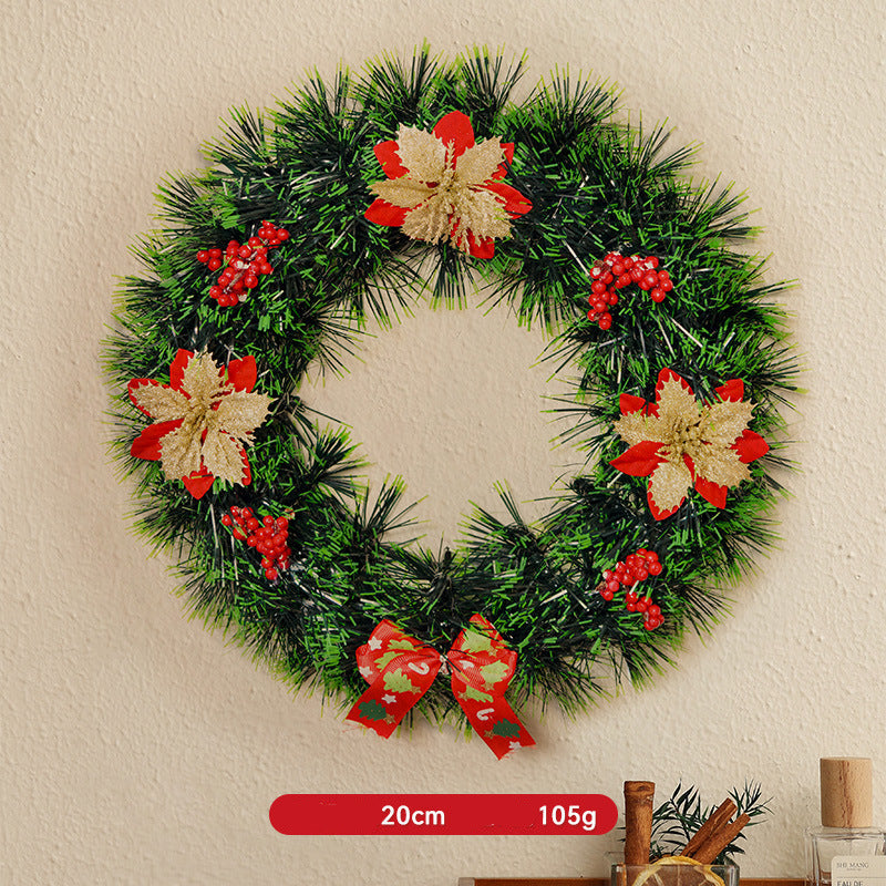Decorative Christmas wreath with red and gold flowers on a beige wall.