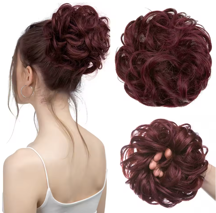 Maroon hair bun extension displayed on a mannequin and held in a hand against a white background.