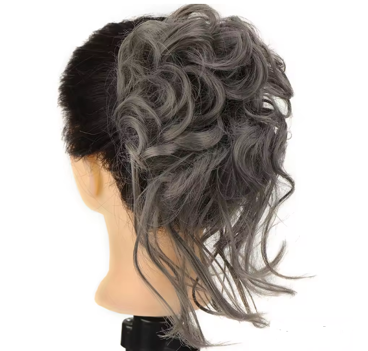Gray hairpiece styled on a mannequin head against a white background